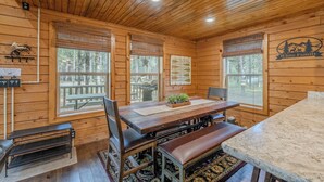 A wooden cabin interior with a dining table, benches, and a sign reading "White Family". - Yellowstone Log Cabin, Family Friendly, Fly Fishing, Trail Riding, Wi-Fi (Island Park)