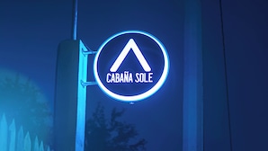 A neon sign with the text "CABANA SOLE" on a vertical pole.