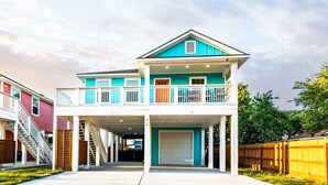 A two-story residential building with a balcony, a garage, and a visible address number.