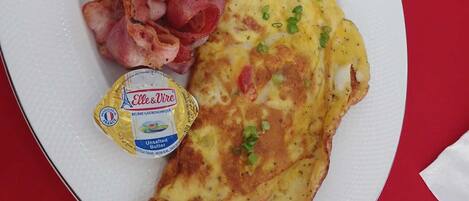 A plate with toast, bacon, and an omelette.