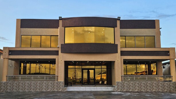 A modern building with a symmetrical facade, large windows, and a central entrance. - CROWN HOTEL GUYANA INC (Georgetown)