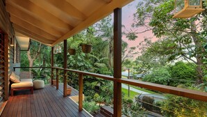 A wooden deck with a railing, a bench, and hanging planters. - Family-Friendly 3BR Home with Outdoor Living in Ferny Hills (Ferny Hills)