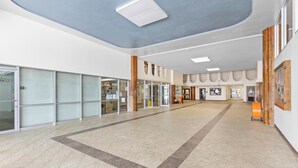 A spacious lobby with a high ceiling, glass doors, and a tiled floor. - Hilo Getaway: 2BR Condo w/ Pool, A/C & Incredible Views (Hilo)