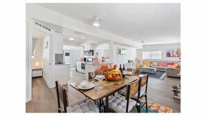 A modern, open-plan living space with a dining area, kitchen, and seating area. - Oasis Paradise/Pool/Mini Golf/Exquisite Escape Sunset/Centric (Port Charlotte)