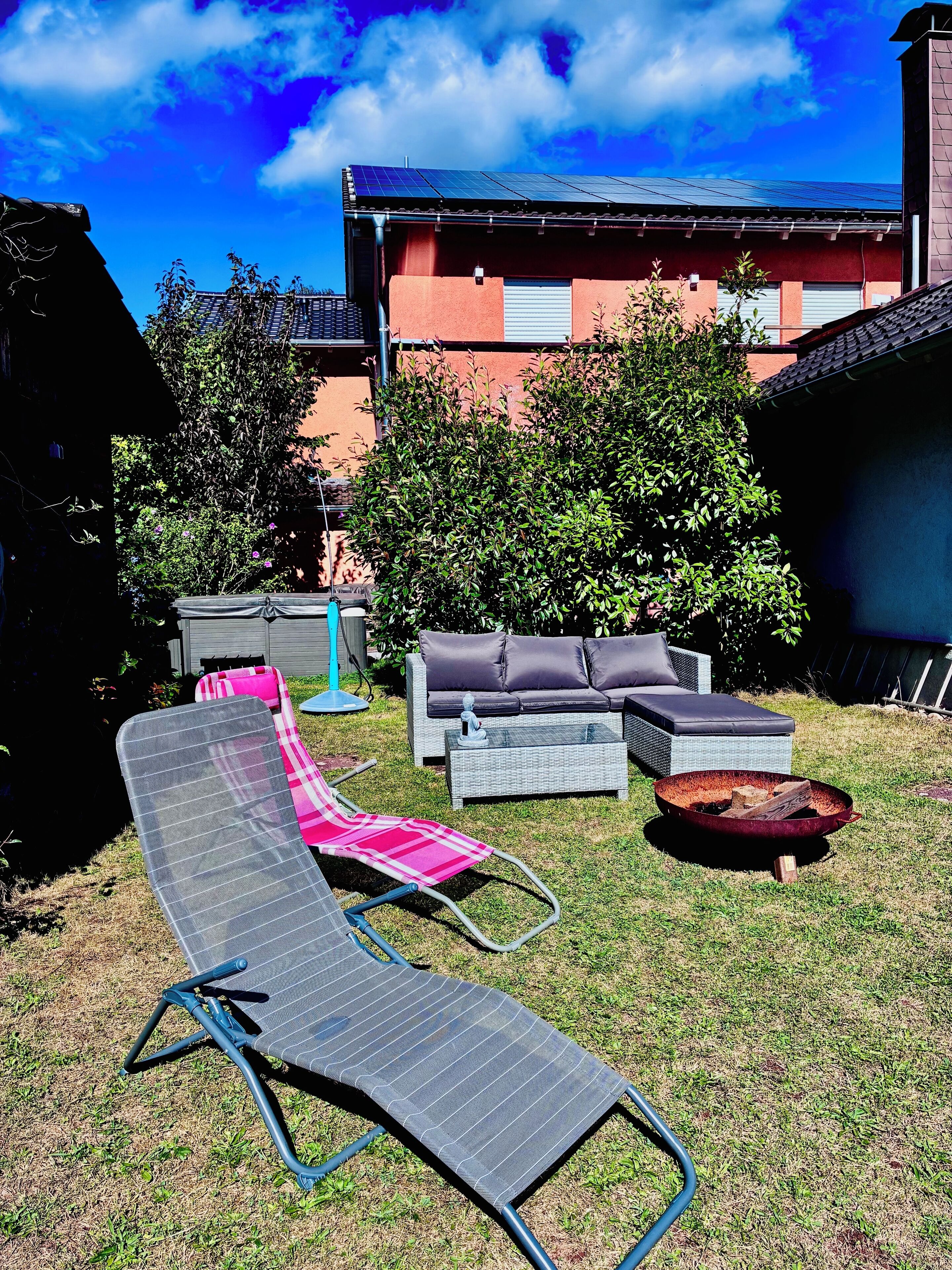 A backyard with a lounge chair, a sofa, and a coffee table.