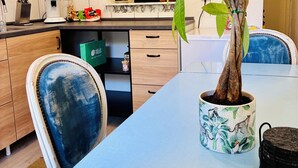A modern kitchen with a marble countertop, wooden cabinets, and a potted plant. - Peace & relaxation in the countryside! Mediterranean country house apartment with jacuzzi (Merchweiler)
