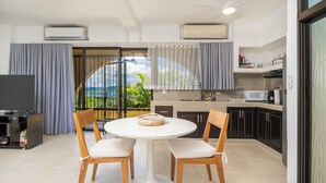 A compact kitchen with a dining area, a TV, and a view of the outdoors. - Studio Apt. Just 5-mins Walk from Flamingo Beach! (Playa Flamingo)
