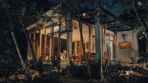A modern house with large glass windows, surrounded by trees and a garden. - Agarthi (Cintalapa)
