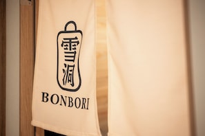 A towel with a logo and the word 'BONBORI' on it. - Bonbori (Nozawaonsen)