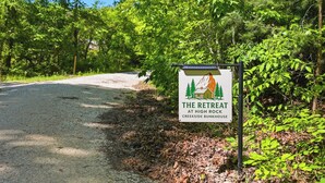 Een bord met 'The Retreat at High Rock Creekside Bunkhouse', met een afbeelding van een rustieke blokhut.