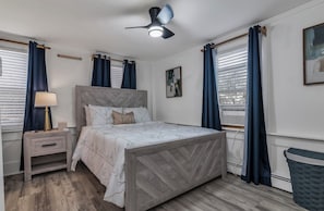 A bedroom with a bed, nightstand, lamp, ceiling fan, and windows with curtains. - Unique 4bedrooms 2 bathrooms stunning getaway unit (Methuen)