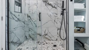 A bathroom with a glass-enclosed shower, marble tiles, and a tiled floor. - Unique 4bedrooms 2 bathrooms stunning getaway unit (Methuen)