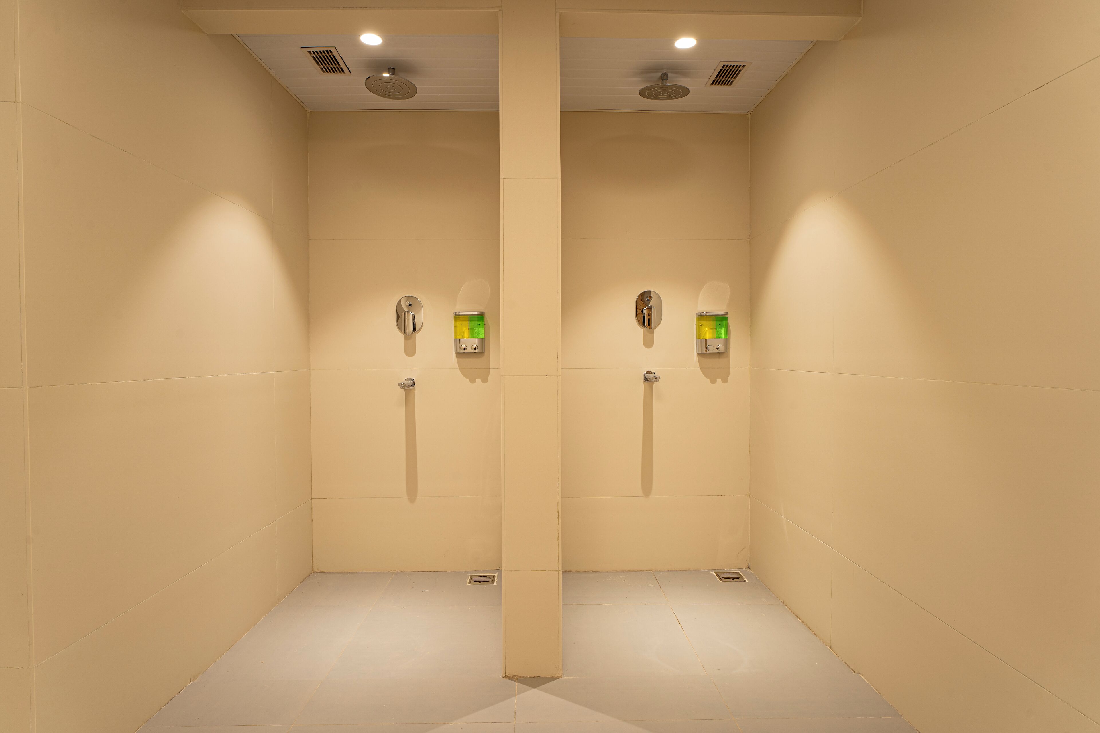 A bathroom with two sinks, a mirror, and a shower area.