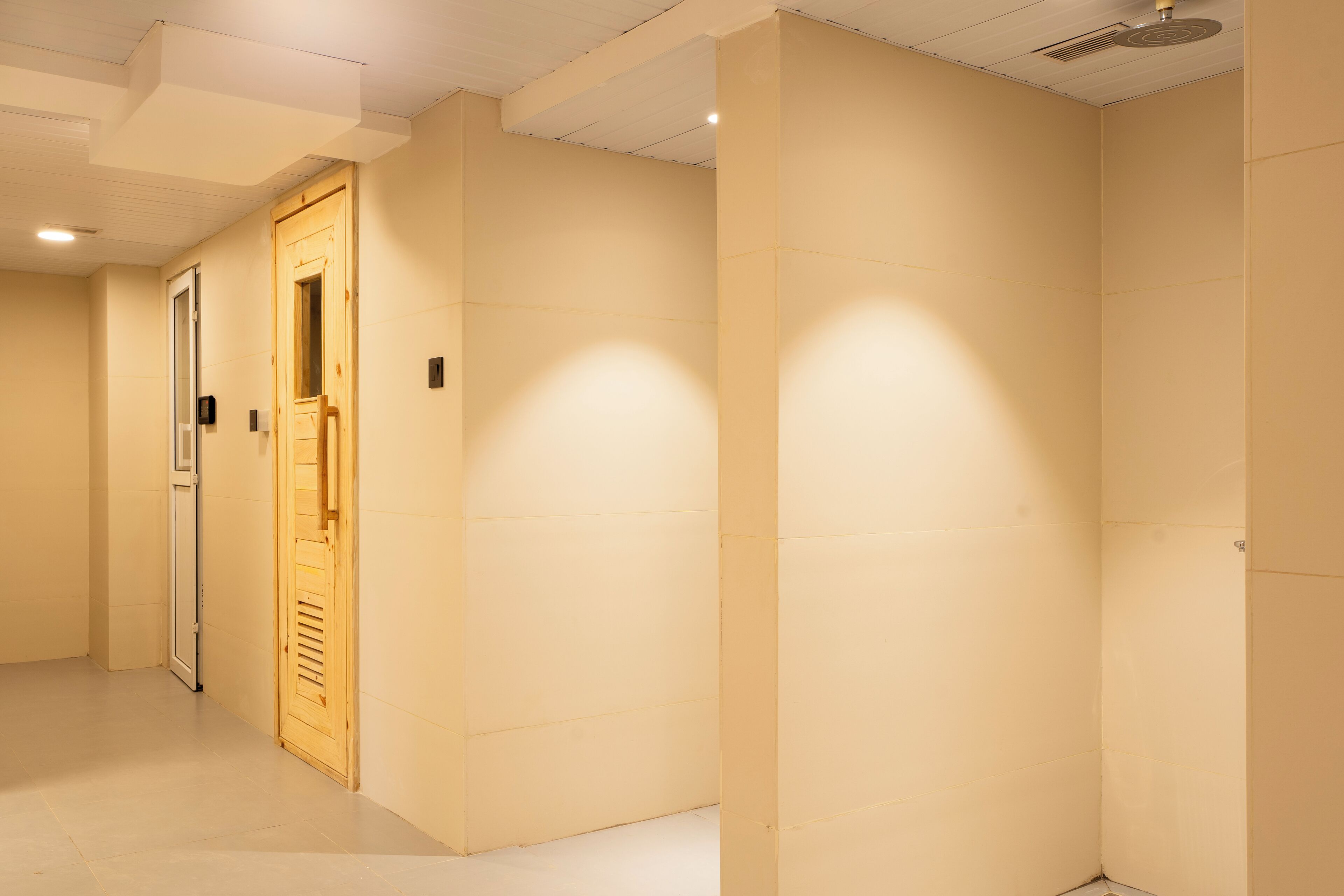Un couloir aux murs de couleur beige et une porte en bois.