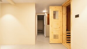 Un pasillo con puerta de madera y un banco.