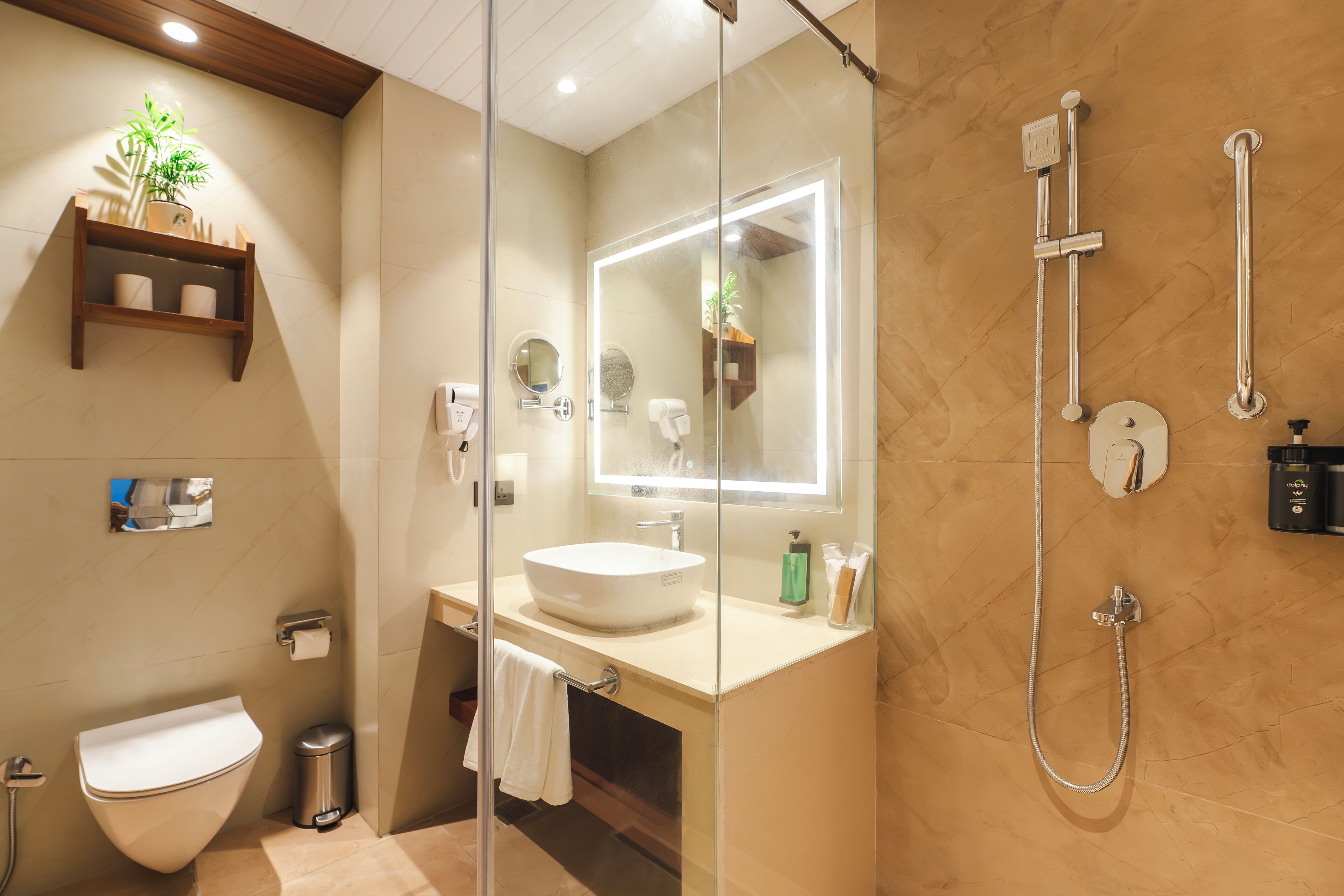 A modern bathroom with a glass-enclosed shower, a white sink, and a mirror with built-in lighting.