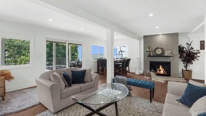 A spacious living room with a fireplace, a glass coffee table, and a sofa.
