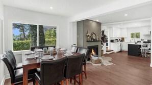 A modern kitchen with white cabinets, a black island, and a fireplace.