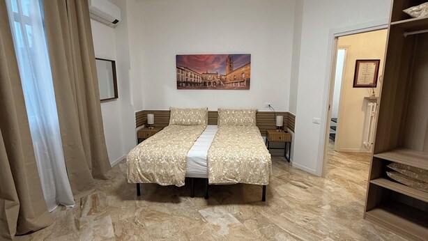 Un dormitorio con cama, un cuadro y suelo de mármol.