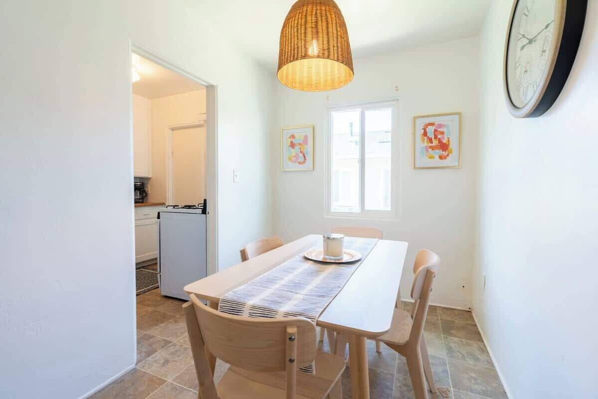 Un espace repas comprenant une table, des chaises, un luminaire suspendu et des œuvres d’art accrochées aux murs.