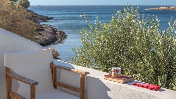 A white chair with a wooden frame, a red book, and a mug on a balcony overlooking the sea. - Art Sounion, Seafront Elegance (Sounion, Lavreotiki)
