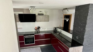 Et moderne køkken med indbygget ovn, vask og bordplade.