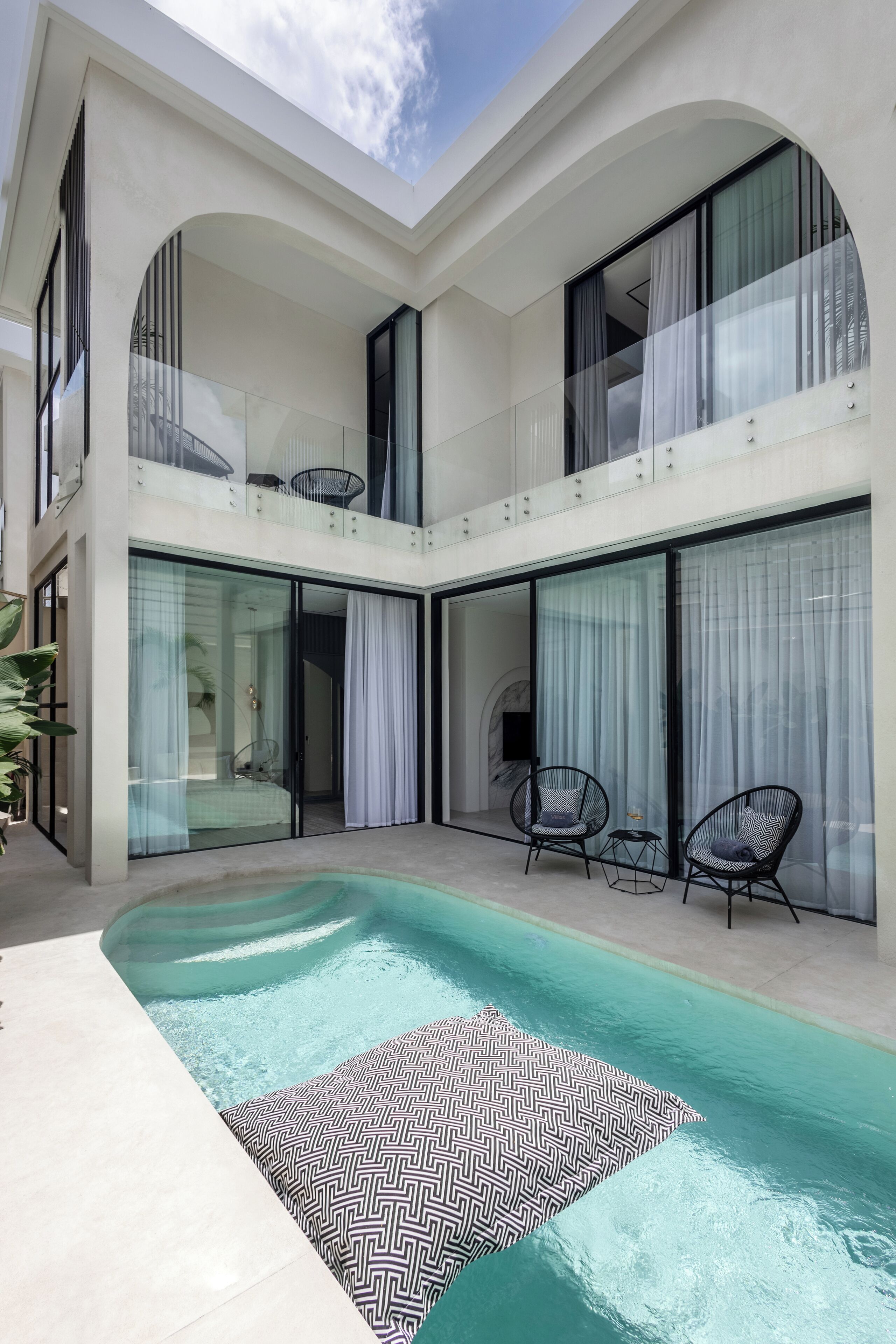 Ein modernes, zweistöckiges Gebäude mit Swimmingpool und Außenbereich.