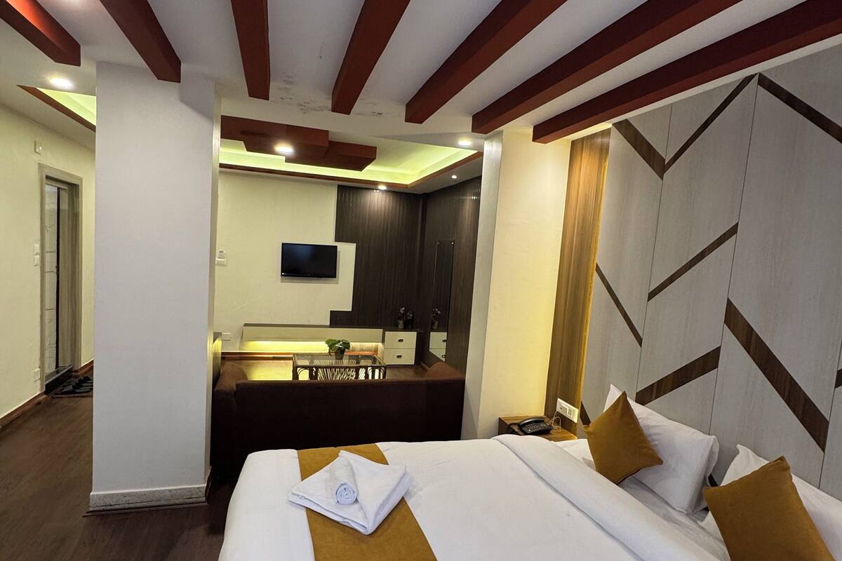 Een hotelkamer met twee bedden, een bureau, een spiegel en een televisie.
