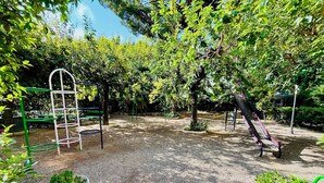 Un parque infantil con un tobogán, estructuras para escalar y un banco.