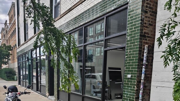 A building with a modern design, featuring large windows and a brick facade. - Grand House (Chicago)