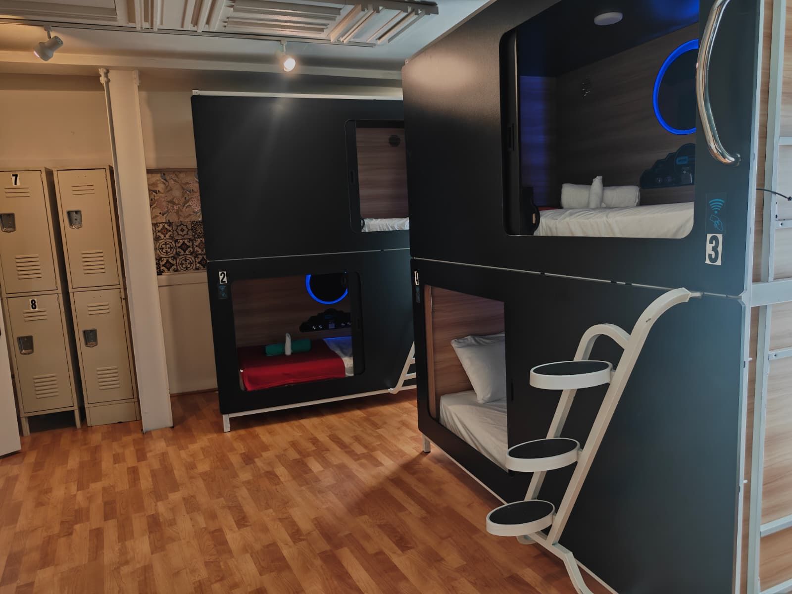A hotel room with bunk beds, a desk, and a wardrobe.