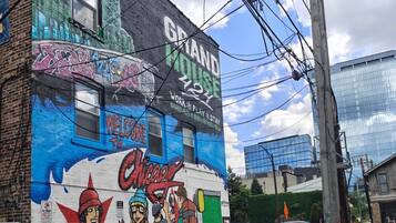 A building with a mural, a garage door, and a car parked on the street.