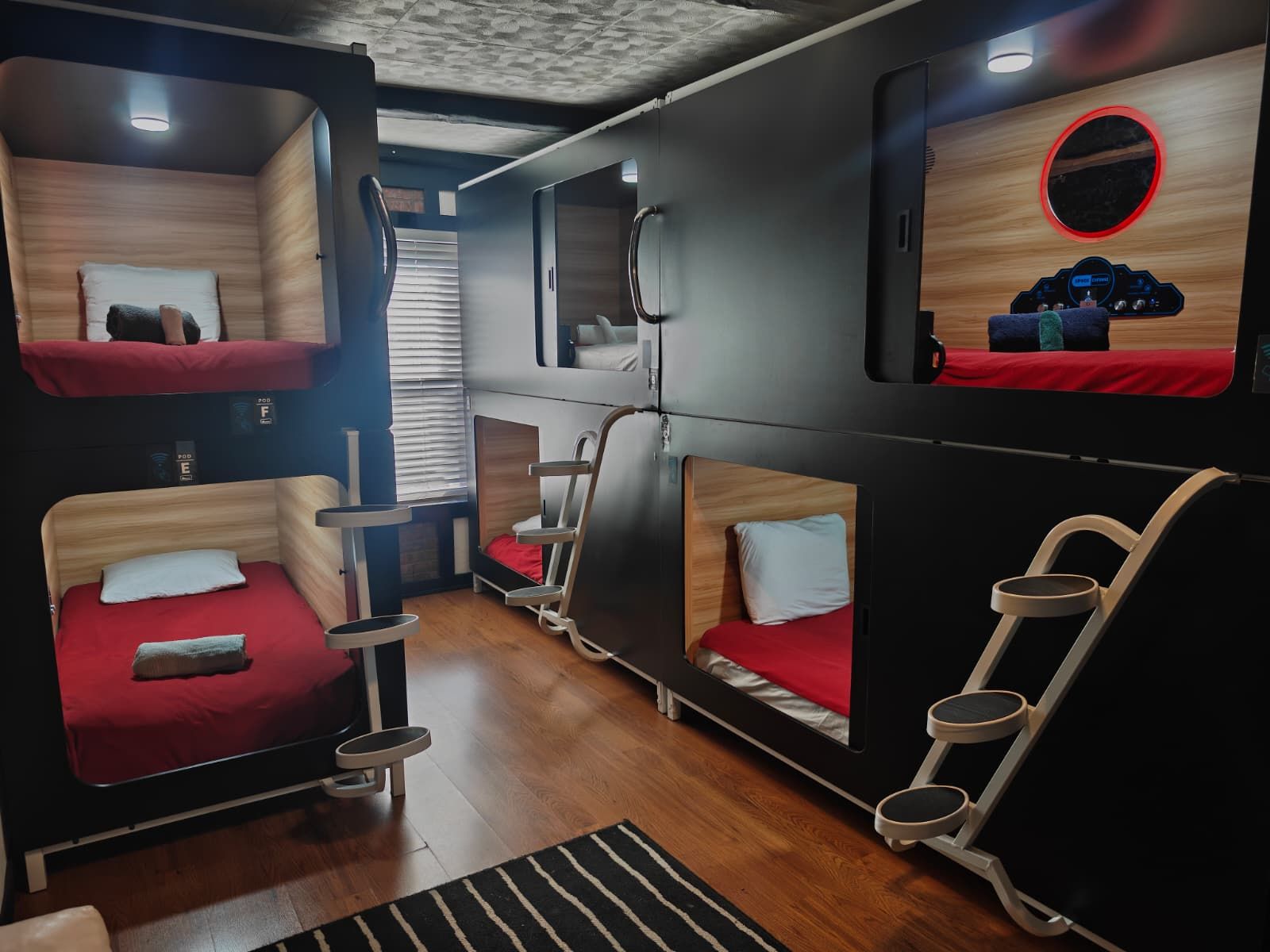 Une chambre de taille réduite avec des lits superposés et un petit coin salon.