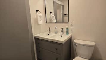 Combined shower/bathtub, hair dryer, slippers, towels