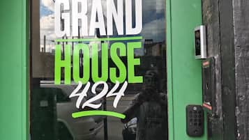 En grön dörr med ett fönster där det står ”GRAND HOUSE 427” och ett lås med knappsats.