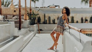 A person standing on a rooftop terrace with a pool, palm trees, and a pergola. - Kenzara Suites & Pool, Your private escape (Marrakesh)