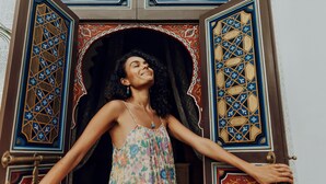 A woman standing in front of a door with intricate geometric patterns and a floral design. - Kenzara Suites & Pool, Your private escape (Marrakesh)