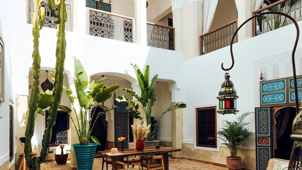 A courtyard with a pool, potted plants, a dining area, and traditional Moroccan architecture. - Kenzara Suites & Pool, Your private escape (Marrakesh)