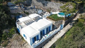 A white building with blue shutters, a swimming pool, and a stone wall. - Villa Dei in Positano - Double Room (Positano)