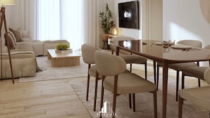 A modern living room with a sofa, coffee table, and dining area.