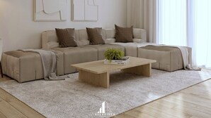A modern living room with a sectional sofa, a coffee table, and abstract wall art.