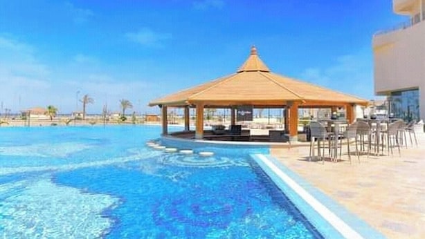 A swimming pool with a gazebo and outdoor seating area.