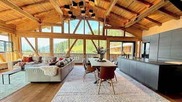 Une pièce spacieuse avec un plafond en bois, un coin repas, un canapé et un espace cuisine.