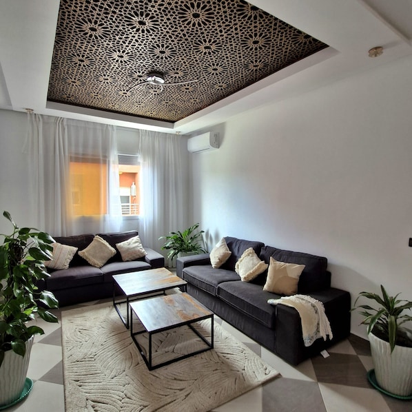 Una sala de estar moderna con un sofá seccional, una mesa de centro y almohadones decorativos.