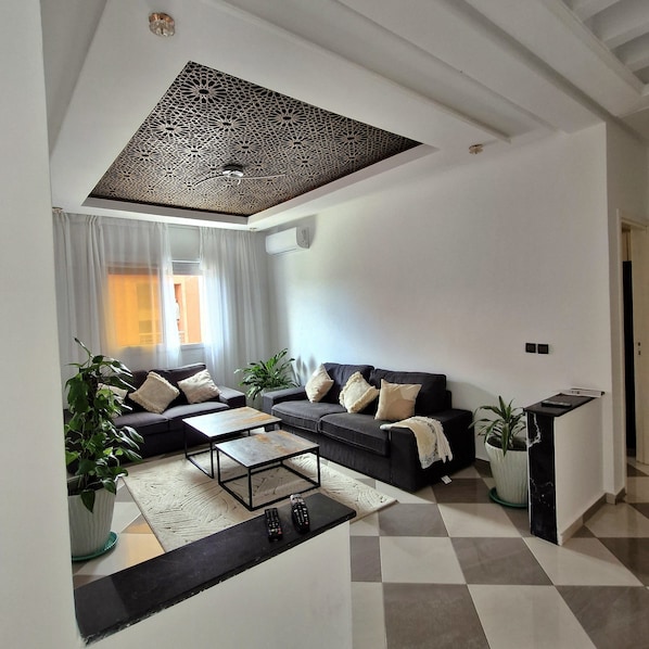 A modern living room with a sectional sofa, a coffee table, and a decorative ceiling.