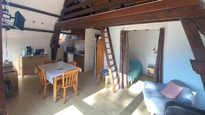 Ett rum i loftstil med matplats, ett litet kök och en sovplats.