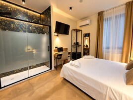 Habitación de hotel con cama, escritorio y televisión.