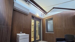 A modern bathroom with a white sink, wooden panel walls, and a glass door leading to a shower area. - Centro & Mare - Rooms & Suites (Termoli)