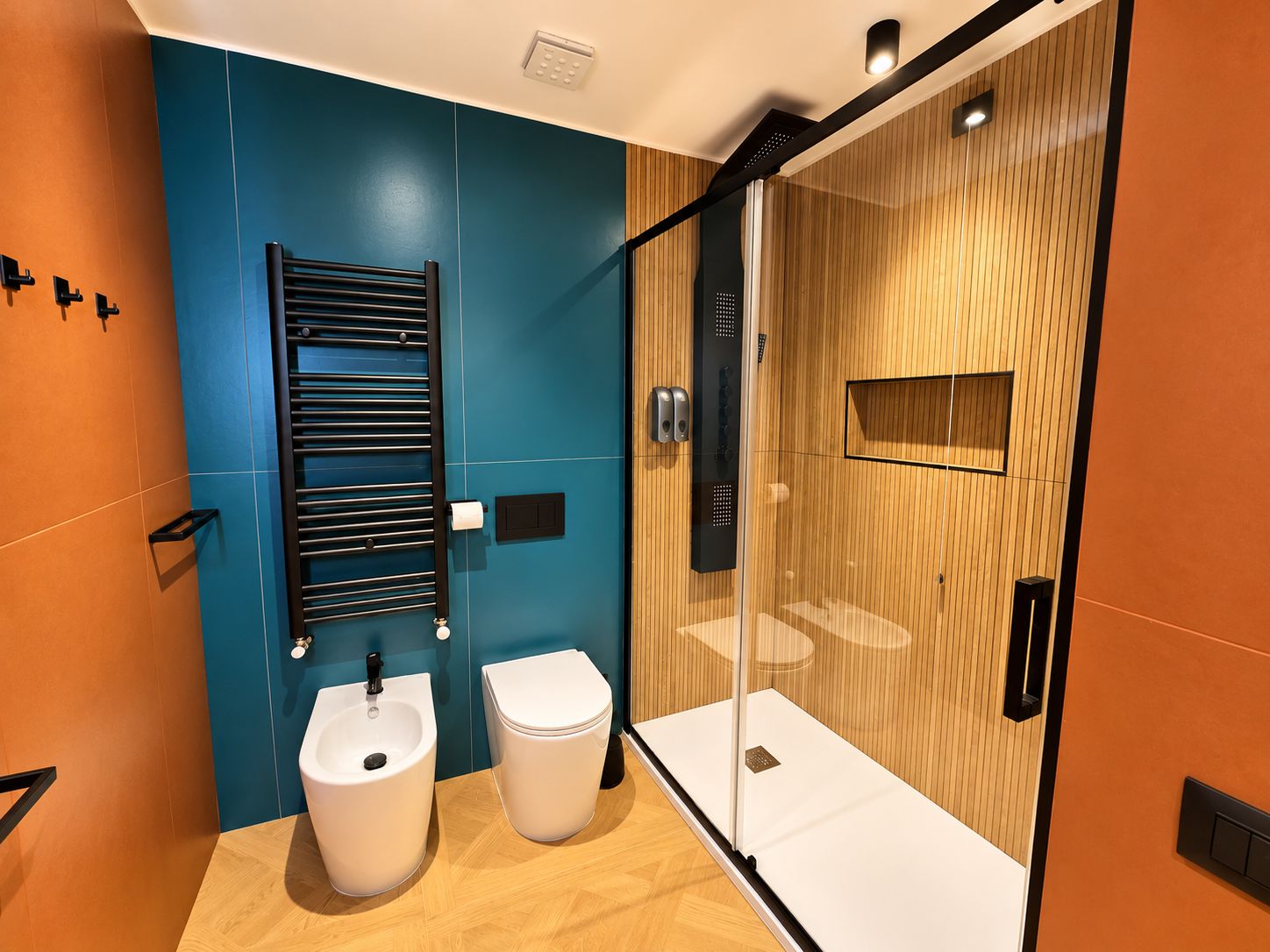 Ein modernes Badezimmer mit einer Bidet, Toilette und einer Duschkabine aus Glas.