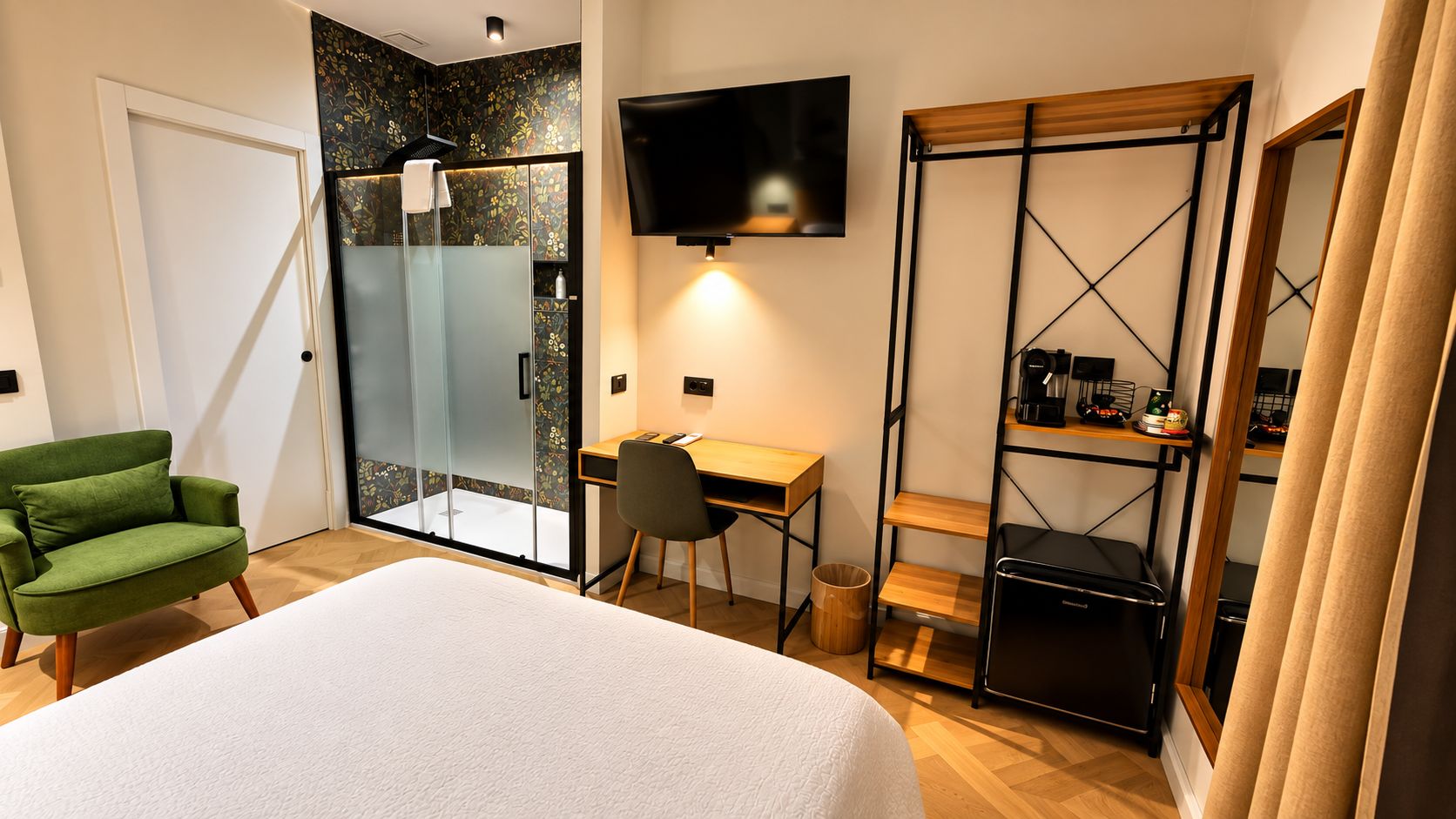 Ein Hotelzimmer mit Bett, Schreibtisch, Stuhl, Fernseher, Kleiderschrank und Dusche.